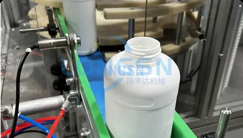 Freshly trimmed HDPE bottle with an open cut neck inside a LONGSN packaging machine